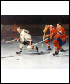 Bobby Hull skating away from two Montreal Canadiens with the puck