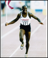 Donovan Bailey célèbre sur la piste avec le drapeau canadien