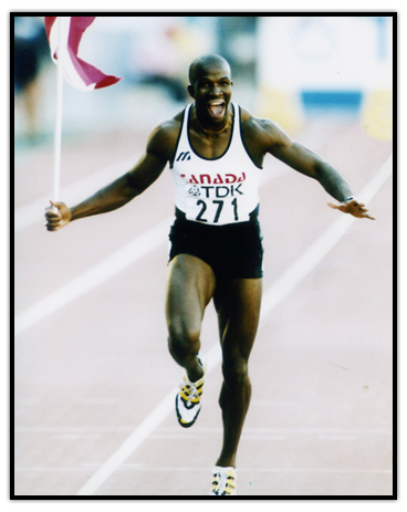 Donovan Bailey celebrates on the track with the Canadian flag