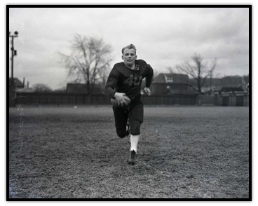 Fritz Hanson on the football field carrying the football