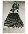 Gordie Howe posing in front of 540 pucks