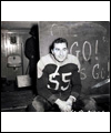 Joe Krol sits down in the locker room behind a chalkboard