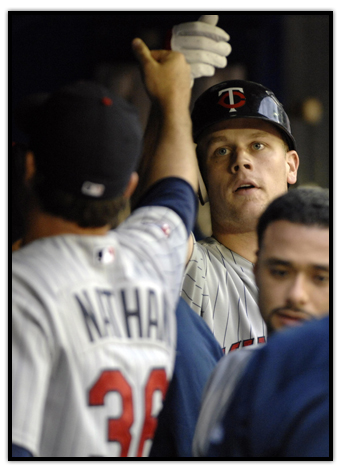 Justin Morneau is congratulated in the dugout after hitting a home-run