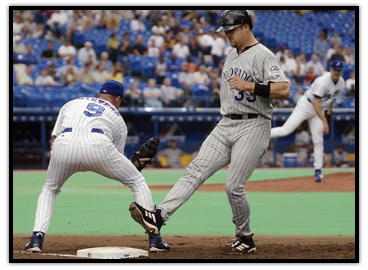 Larry Walker goes back to first base on a pickoff attempt