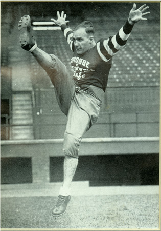 Lionel Conacher en position pour effectuer un botté sur le terrain de football.