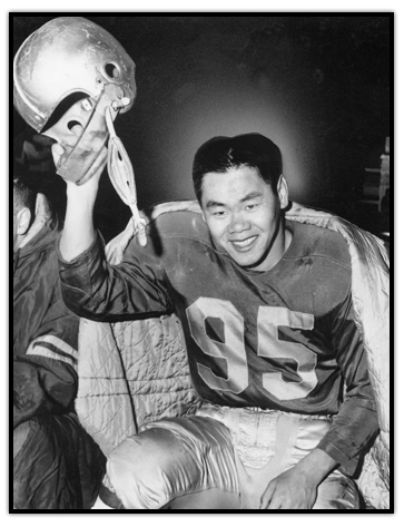 Normie Kwong smiling while raising his helmet