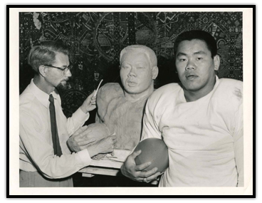 Normie Kwong standing beside his sculpture