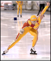 Susan Auch skating with one arm in the air