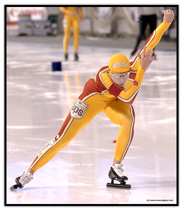 Susan Auch skating with one arm in the air